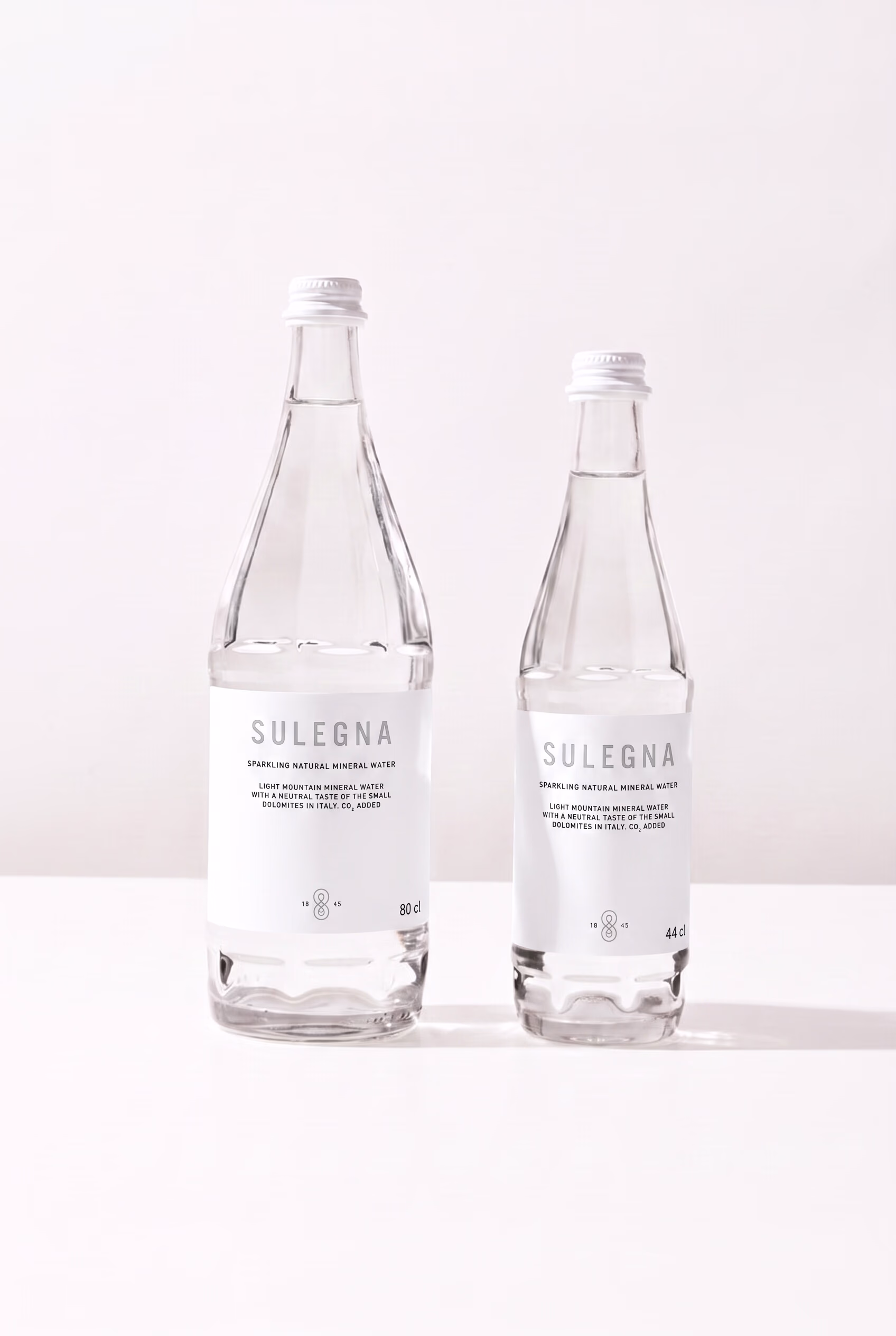 Steklenici SULEGNA Sparkling, 80 cl in 44 cl, druga ob drugi na belem